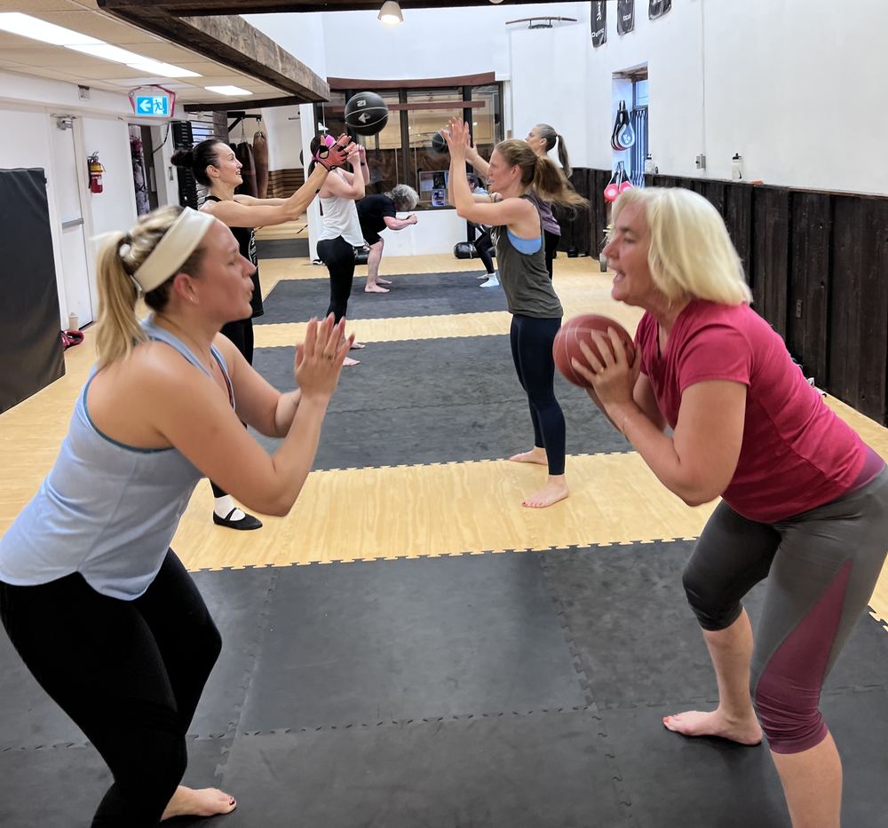 Two members doing a partner medicine-ball drill